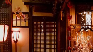 Un interior japonés tradicional con puerta de madera, suelo de piedra y un farol.