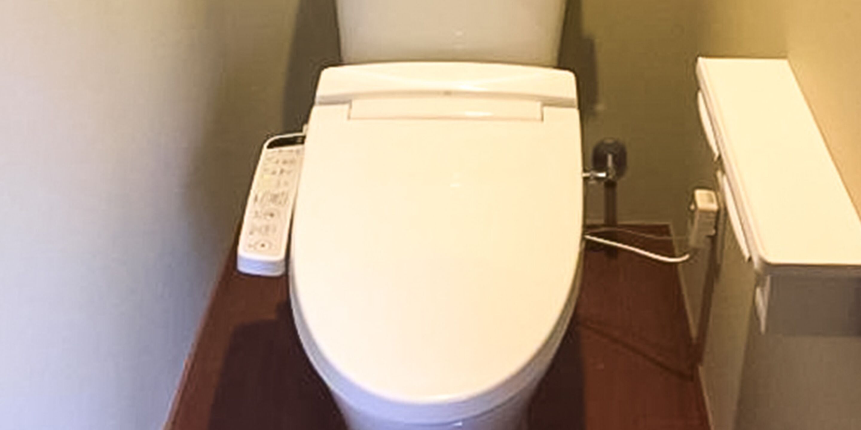 A white toilet with a control panel on the left side.