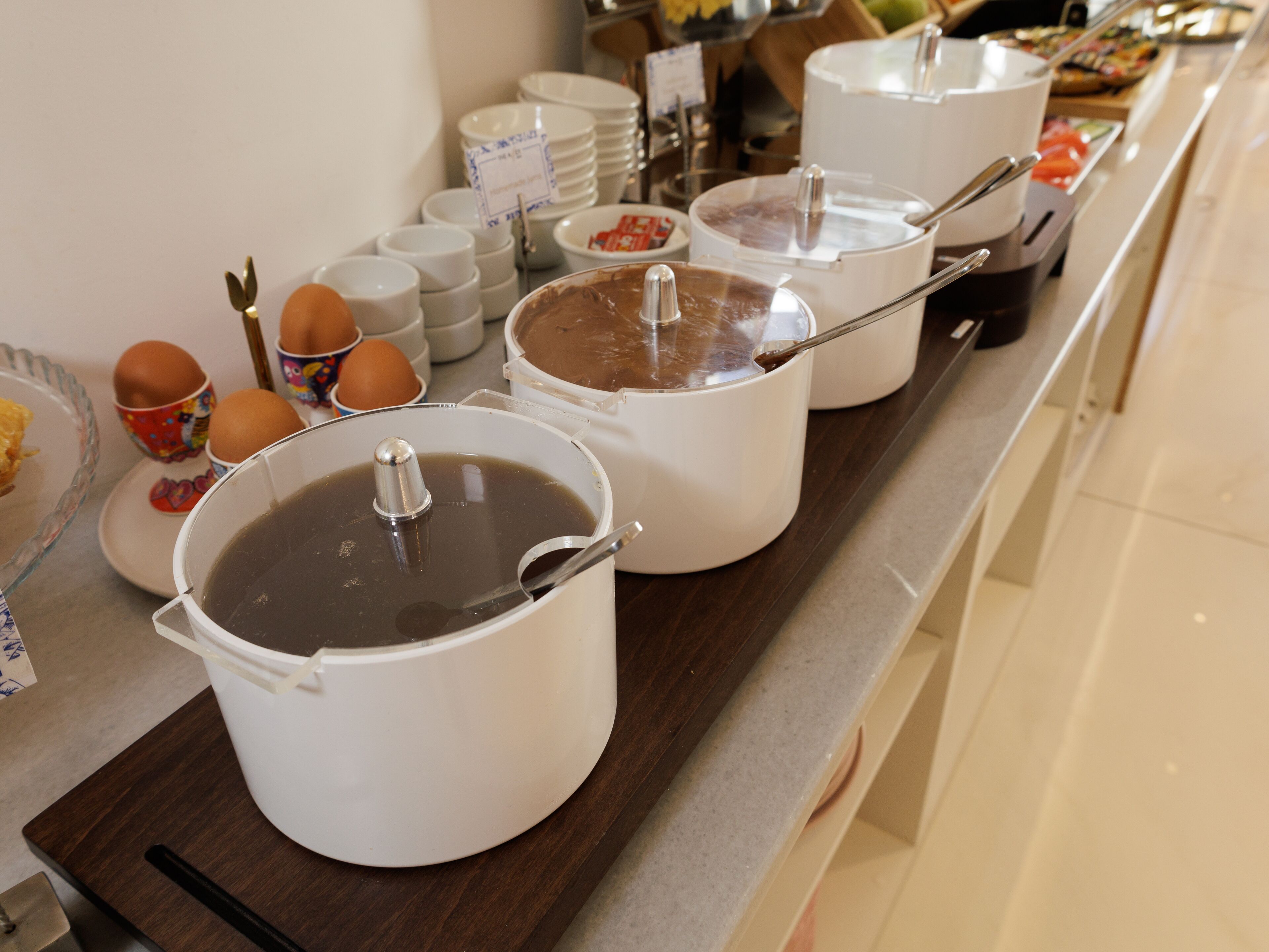 A buffet setup with various food items and containers.