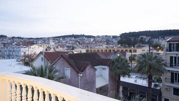 A residential area with buildings, some with red-tiled roofs, and palm trees.