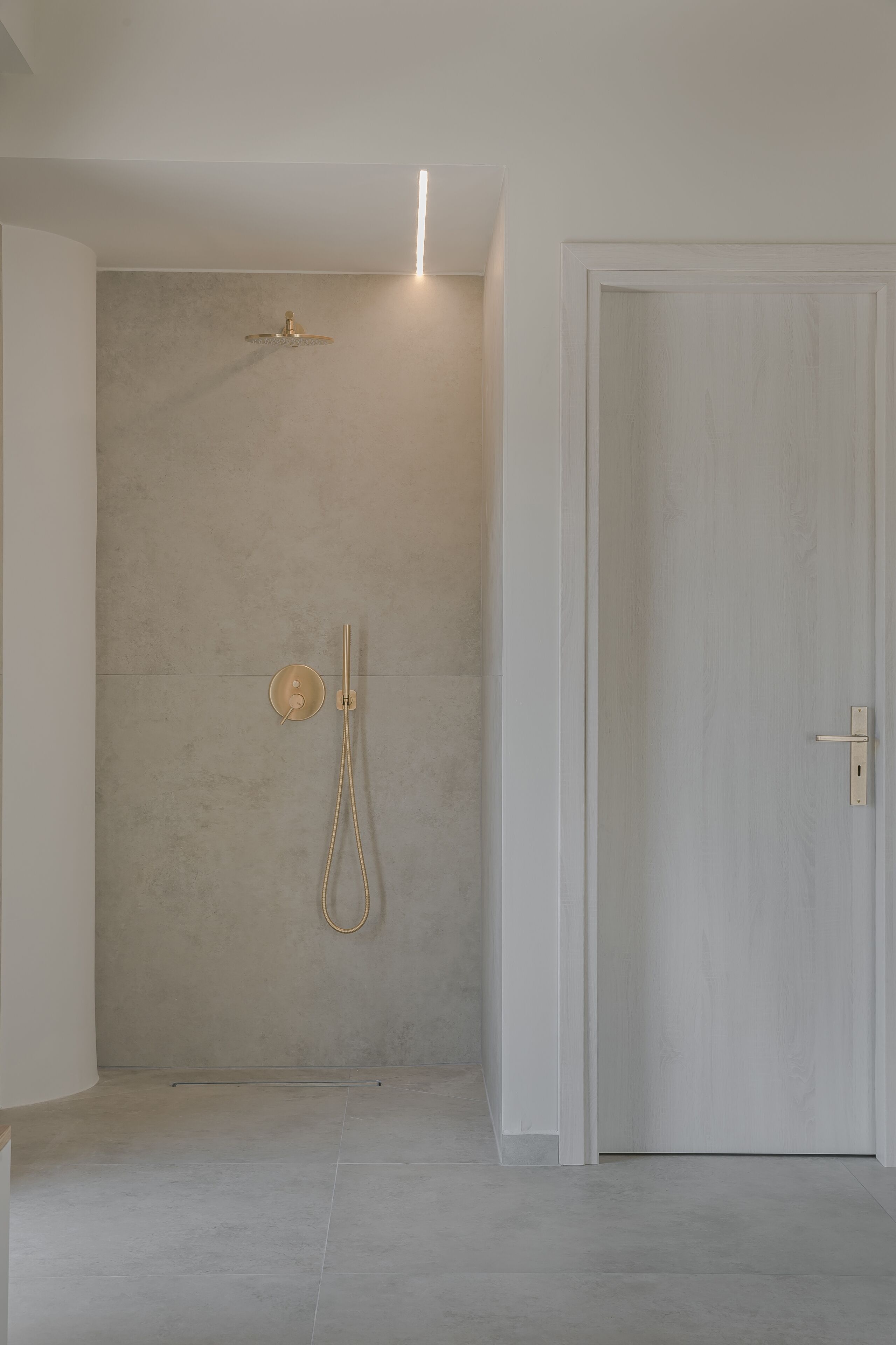 Un baño minimalista con ducha, inodoro y puerta.