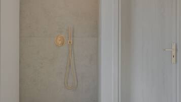 Un baño minimalista con ducha, inodoro y puerta.