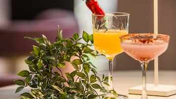 Dos bebidas sobre una mesa con una lámpara y una planta.