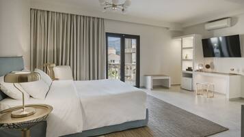 Una habitación de hotel moderna con una cama grande, un escritorio, un televisor y un balcón con vistas.