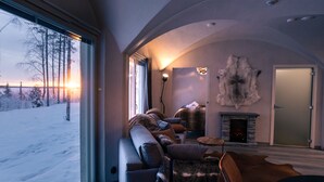 Un salon chaleureux avec une grande fenêtre, une cheminée et un tapis en fourrure.