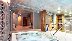 Un spa moderne doté d’un jacuzzi, de touches décoratives en bois et de murs carrelés.