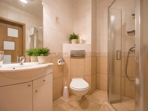A bathroom with a sink, toilet, and shower. - VacationClub - Olymp Apartments (Kolobrzeg)