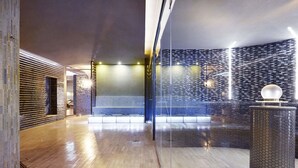 Un hall d’entrée moderne avec un plancher en bois, une cloison en verre et une colonne décorative.