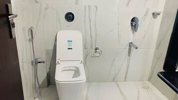 A modern bathroom with a white toilet, a bidet, and a shower.