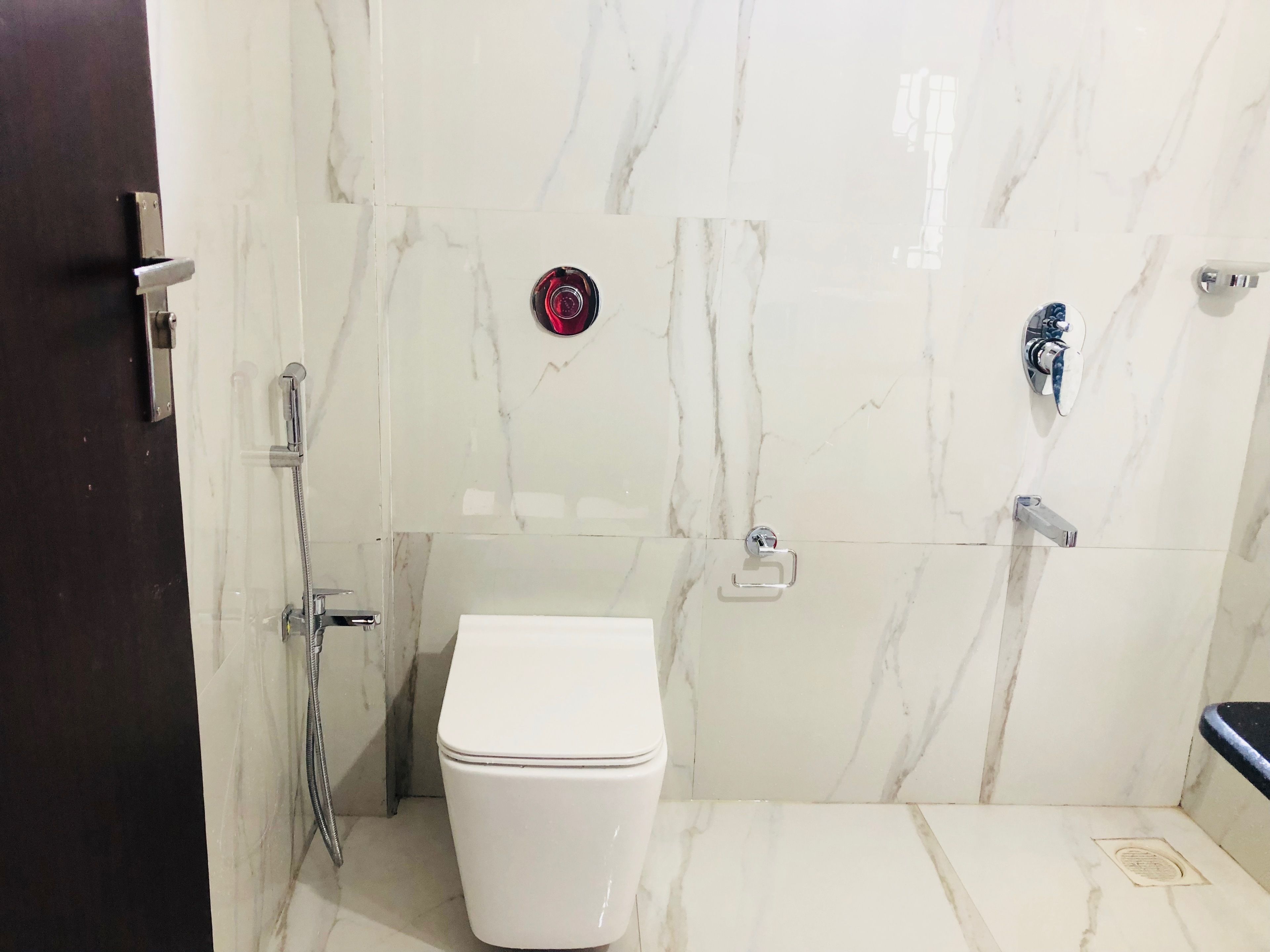 A bathroom with a white toilet, a shower, and a sink.