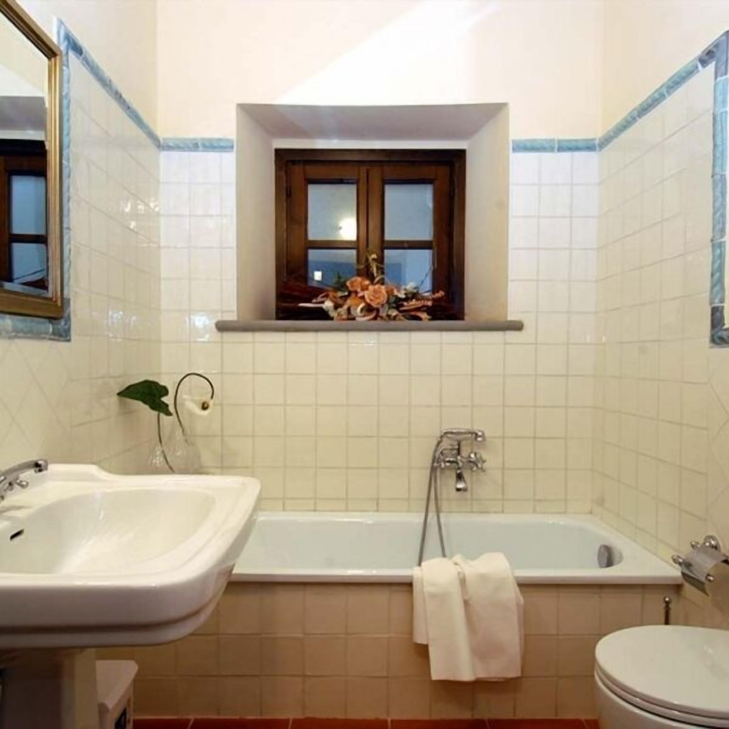 Un baño con bañera, lavabo e inodoro.