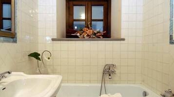 Un baño con bañera, lavabo e inodoro.