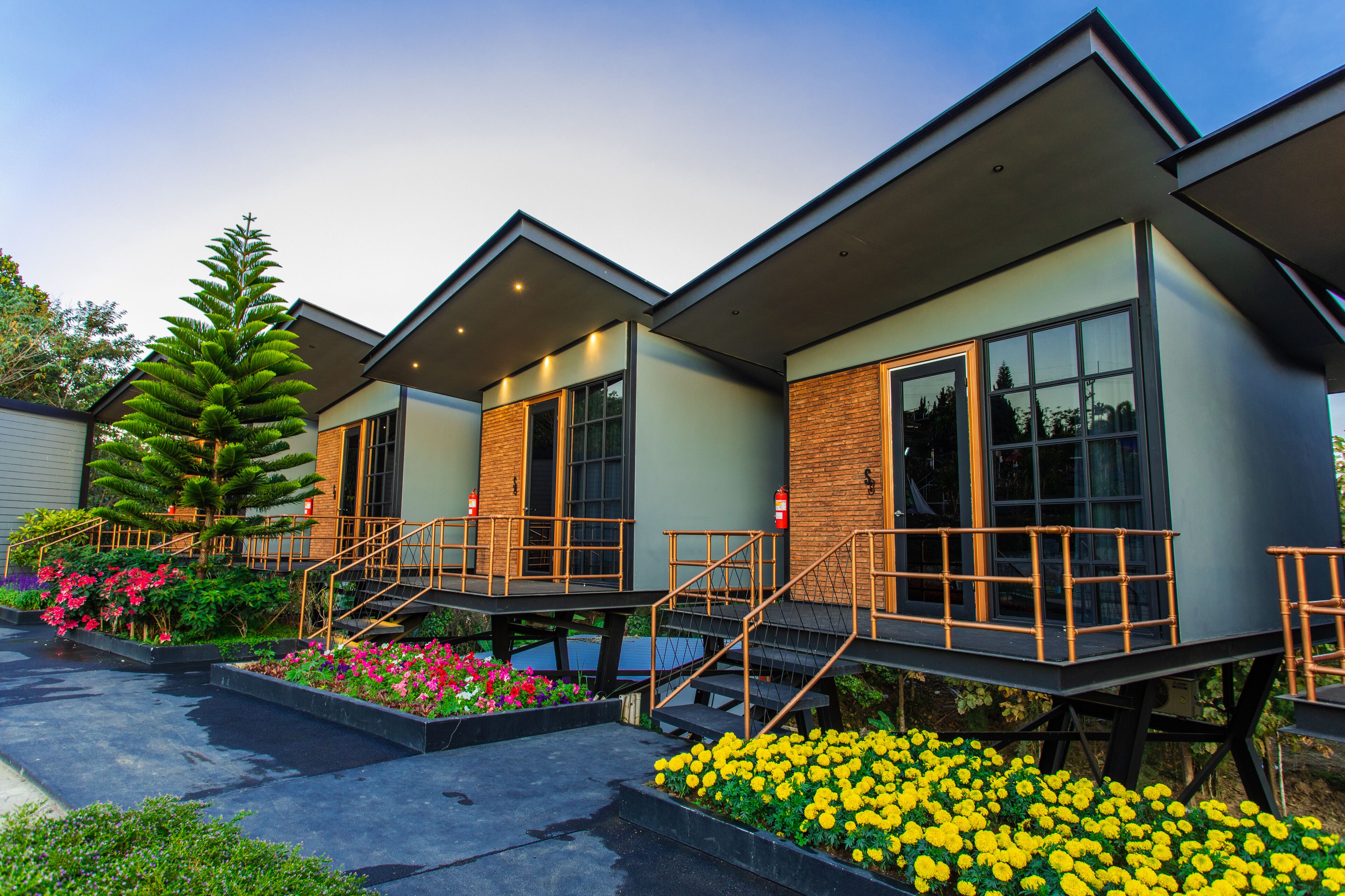 A modern hotel with multiple units, each featuring a balcony and a staircase leading to the entrance.
