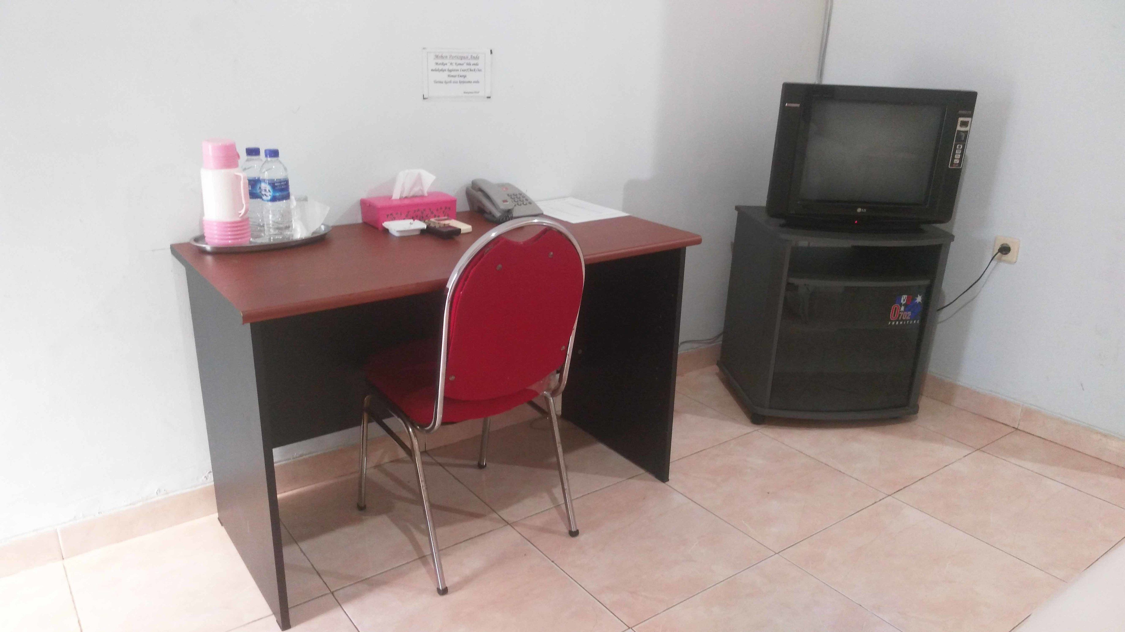 A small office with a desk, chair, and a television.