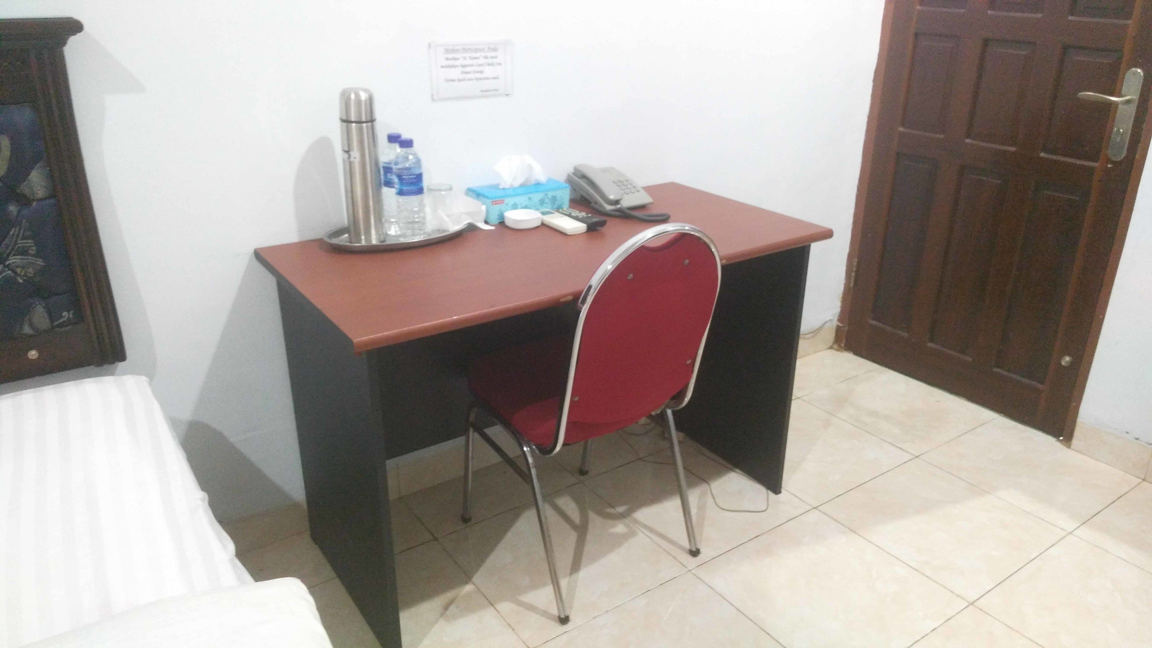 Una habitación pequeña con una cama, un escritorio y una silla.