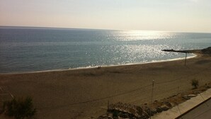 A beach with a clear view of the ocean, a sandy shore, and a small structure near the water's edge. - Ariadni Hotel by Estia (Viannos)