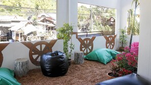 Habitació amb vistes a un poble, un seient de sacs negre i un coixí verd.