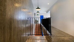 A modern interior with a staircase, metal railings, and pendant lighting. - Sai Hometel (Koh Tao)