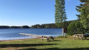 Un área de picnic junto al lago, con bancos y un muelle que se adentra en el agua.