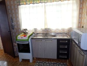 Apartamento família, 3 quartos | Cozinha americana privada | Geladeira, micro-ondas, fogão, cooktop