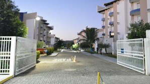 A gated residential area with multi-story buildings, paved pathways, and greenery. - Enseada Residence (Caldas Novas)