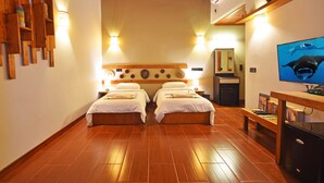 Quarto com duas camas, piso de madeira, televisão e teto de madeira.