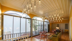 A spacious room with large windows, a balcony, and a seating area with chairs and a sofa. - Delight Deluxe Hotel (Antalya)