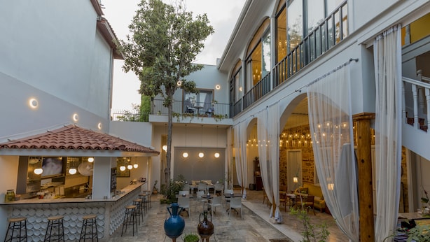 A courtyard with a bar, seating area, and a staircase leading to an upper level. - Delight Deluxe Hotel (Antalya)