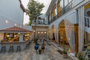 Un patio con bar, zona de estar y una escalera que lleva a un nivel superior.