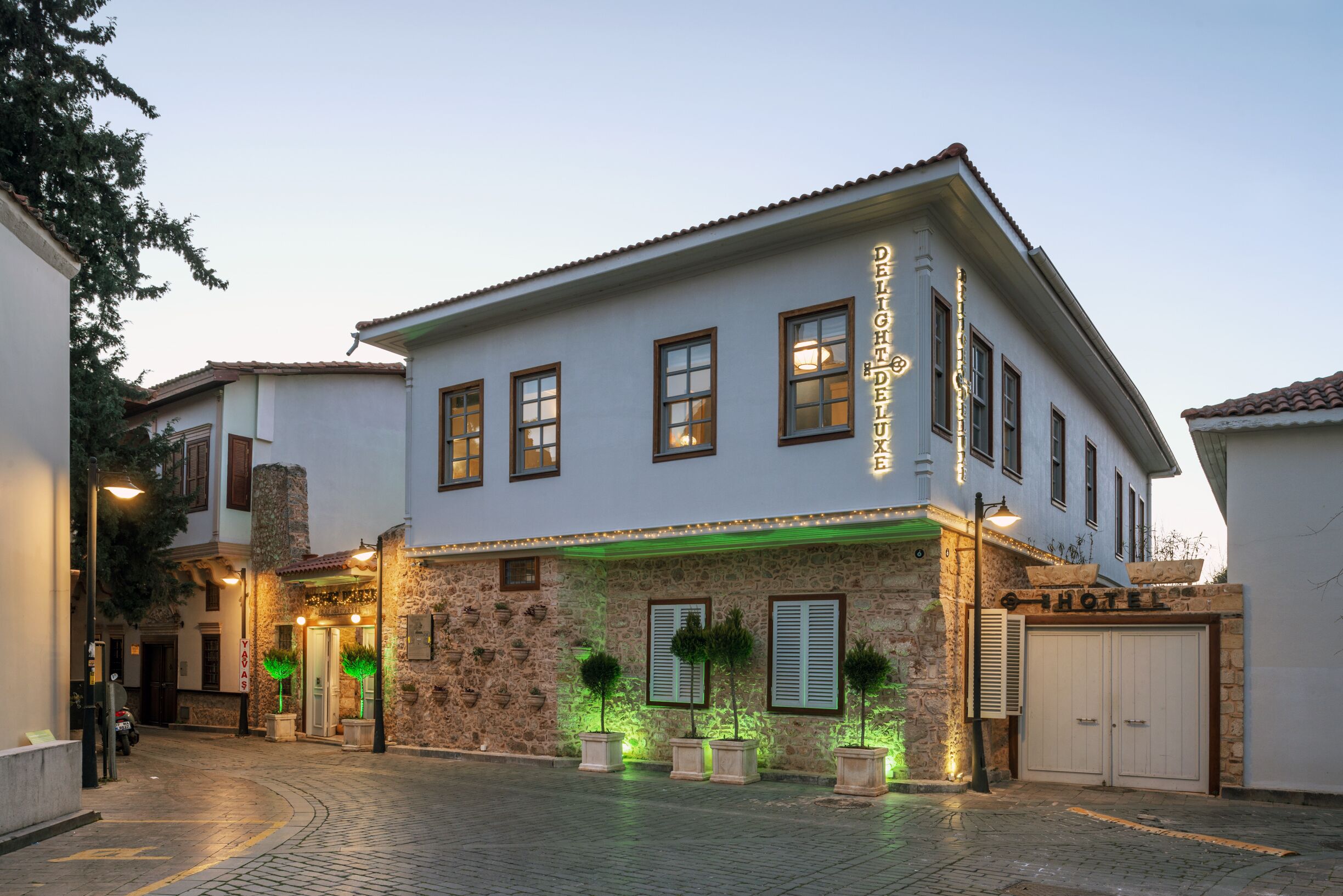 Un hotel con fachada de piedra, varias ventanas y un letrero que indica que es un hotel.