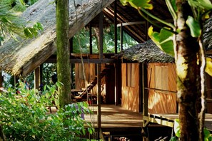 A wooden structure with a thatched roof, surrounded by lush greenery. - Punta Brava (Nuquí)