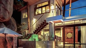 A modern house with a swimming pool, outdoor seating, and a staircase leading to an upper level. - Villas Del Sol Resort (Koh Tao)