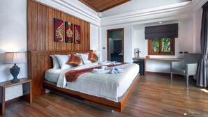 A spacious bedroom with a large bed, wooden headboard, and a desk with a chair. - Villas Del Sol Resort (Koh Tao)