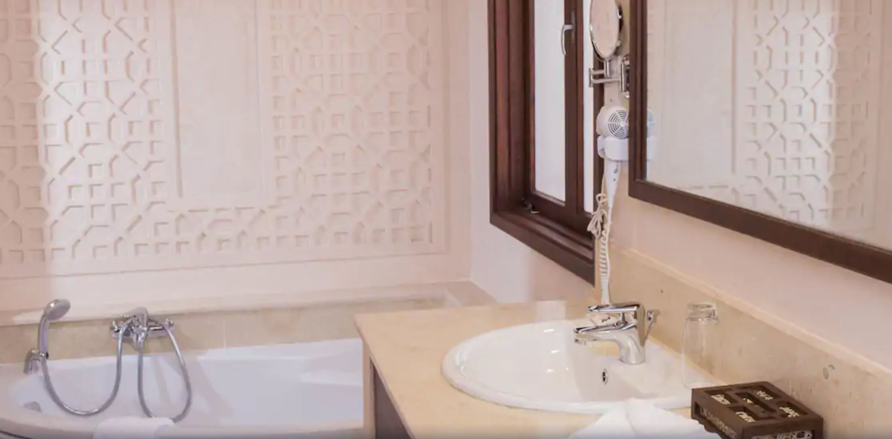 Une salle de bain avec une baignoire, un lavabo et un miroir.