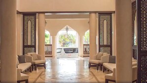 A spacious lobby with a central seating area, high ceilings, and decorative wooden screens. - Silver Palm Spa and Resort (Kilifi)