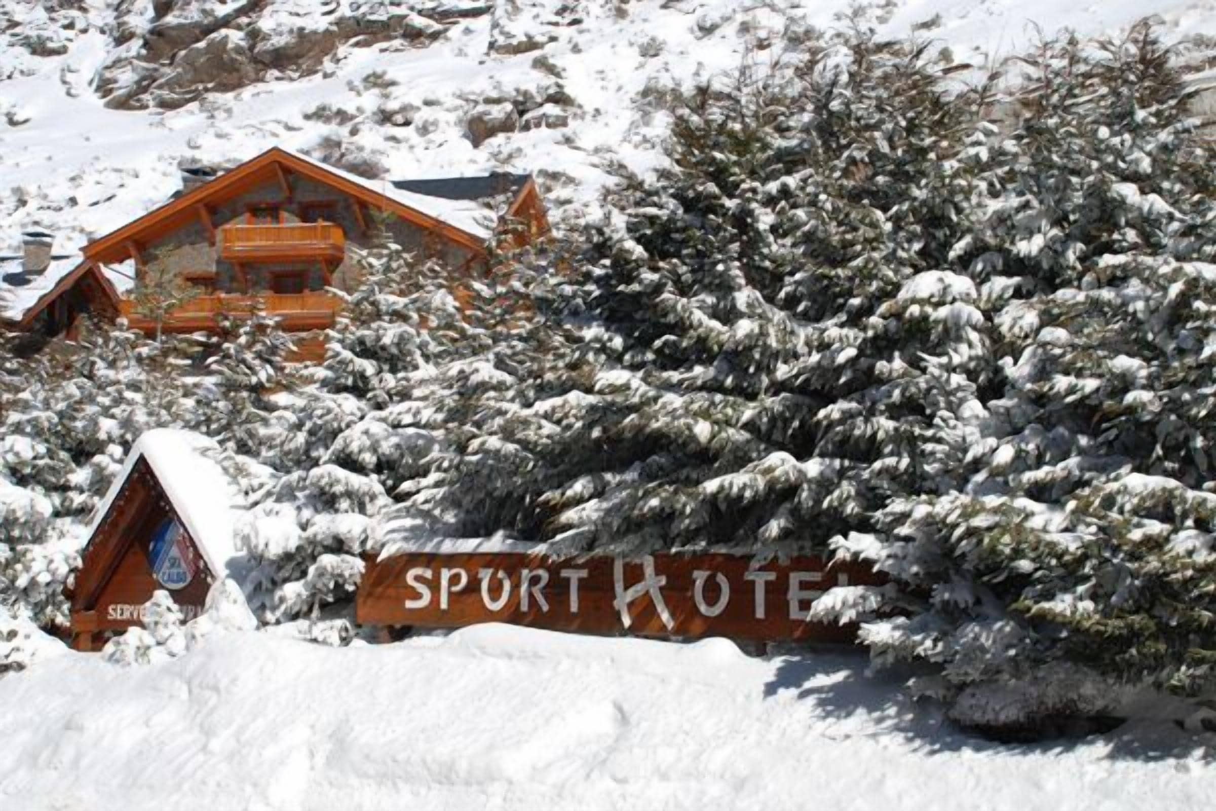 A snow-covered lodge with a sign reading "SPURTHOTEL".