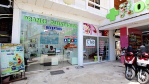 A reception area with a sign for 'Pranee Guesthouse' and a 'Cleave Nails Salon' across the street. - Pranee Guesthouse (Koh Tao)