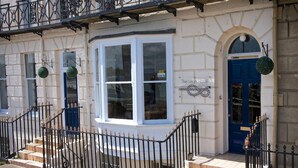 A building with a white facade, a blue door, and a sign reading "The Lean Hotel." - The Leam Hotel (Weymouth)