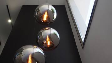Tres lámparas colgantes esféricas con bombillas de filamento expuesto suspendidas de un techo negro.