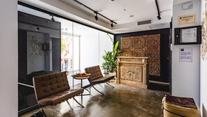 Eine moderne Lobby mit einer Couch, Sesseln, einem Kamin und einem großen Fenster.