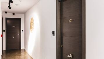 A hallway with two dark wooden doors, one labeled '102' and another with a visible number '103'.