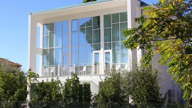 Un edificio moderno con grandes ventanales y un balcón.