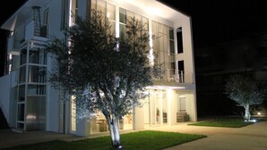 Un edificio moderno de dos pisos con ventanas amplias y un balcón.