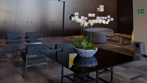 Un hall d’entrée moderne avec des sièges, un comptoir d’accueil et un mur décoratif orné de cartes.
