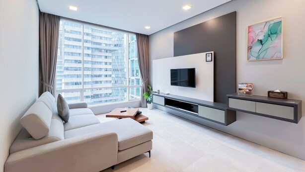 A modern living room with a large window, a sofa, a flat-screen TV, and a minimalist entertainment unit. - Soho Suites KLCC by leala (Kuala Lumpur)