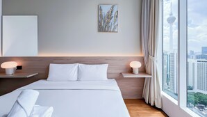 A modern hotel room with a large bed, two bedside tables with lamps, a city view, and a framed artwork on the wall. - Soho Suites KLCC by leala (Kuala Lumpur)