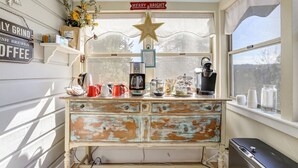 Una cocina rústica con una cafetera antigua, un adorno de estrella y un letrero que dice 'Merry & Bright'.