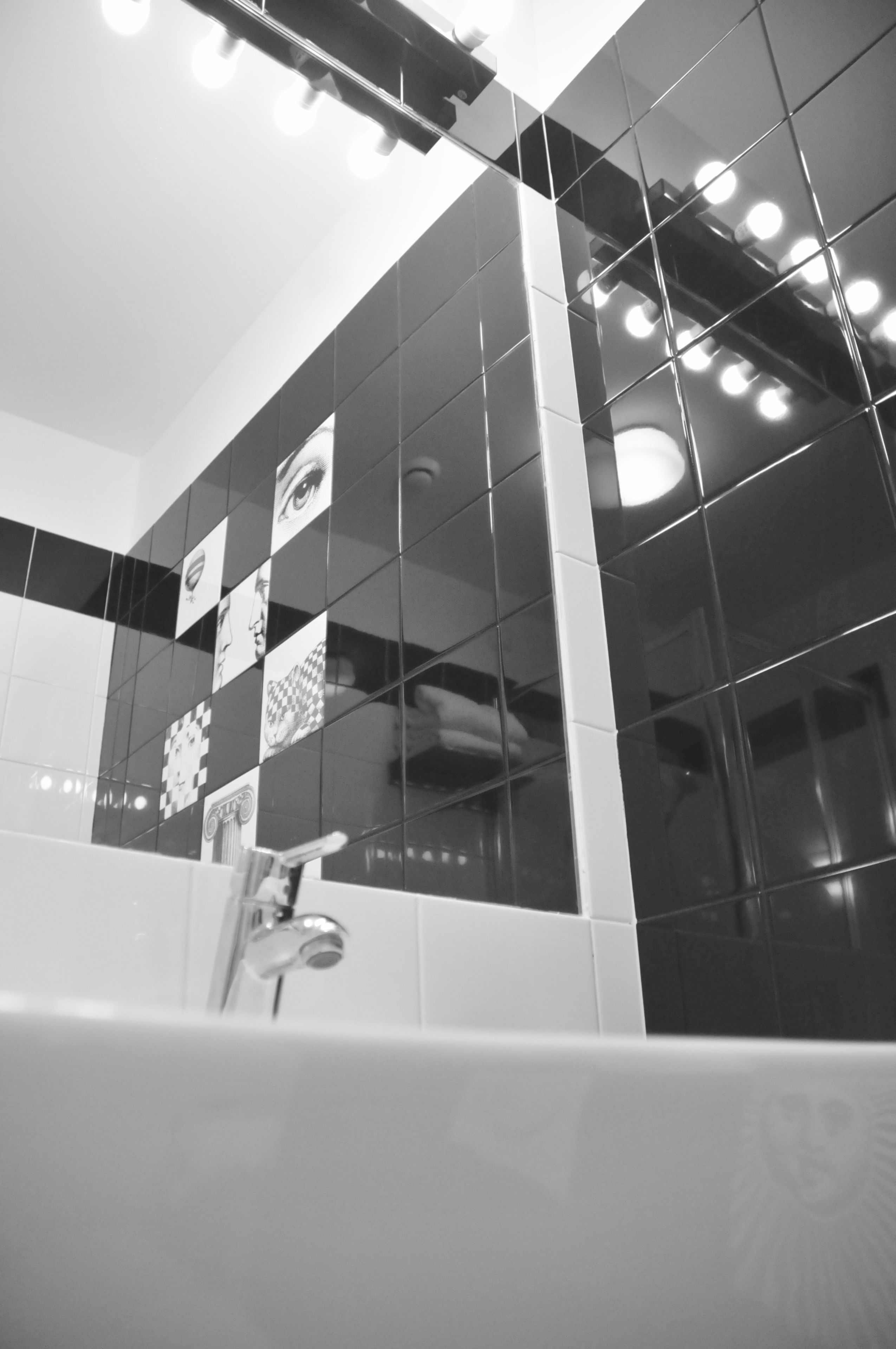 Un bagno dal design moderno, con uno specchio grande, una vasca e un lavabo.