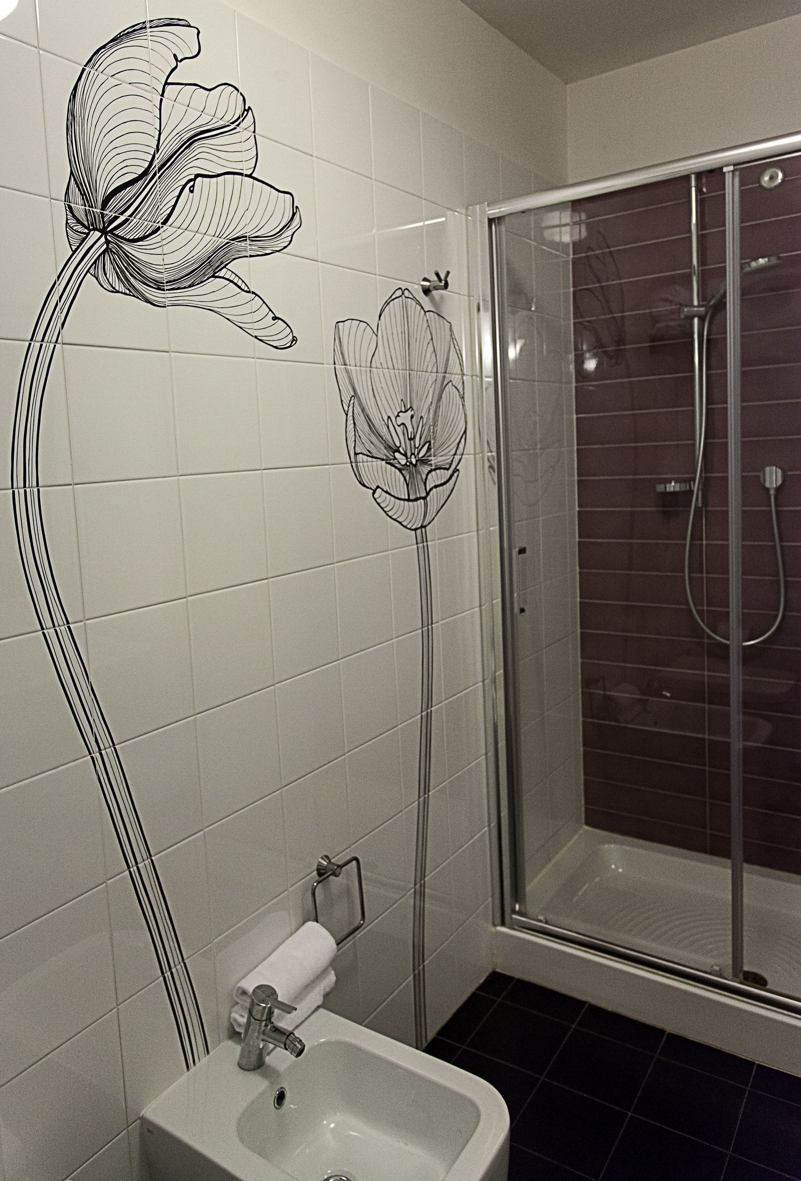 A bathroom with a shower, a sink, and a toilet.