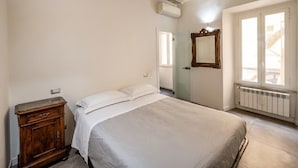 Un dormitorio con cama, cómoda, espejo y ventana con vistas.